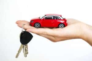 mini red car in palm with keys