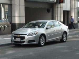 used silver chevrolet malibu driving down a street