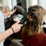 A woman get her hair blown out and curled at a Salon