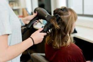 A woman get her hair blown out and curled at a Salon