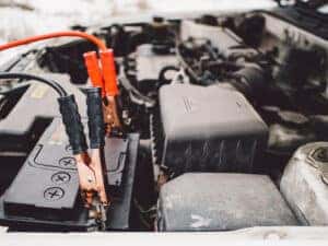 car jumper cables connected to a battery