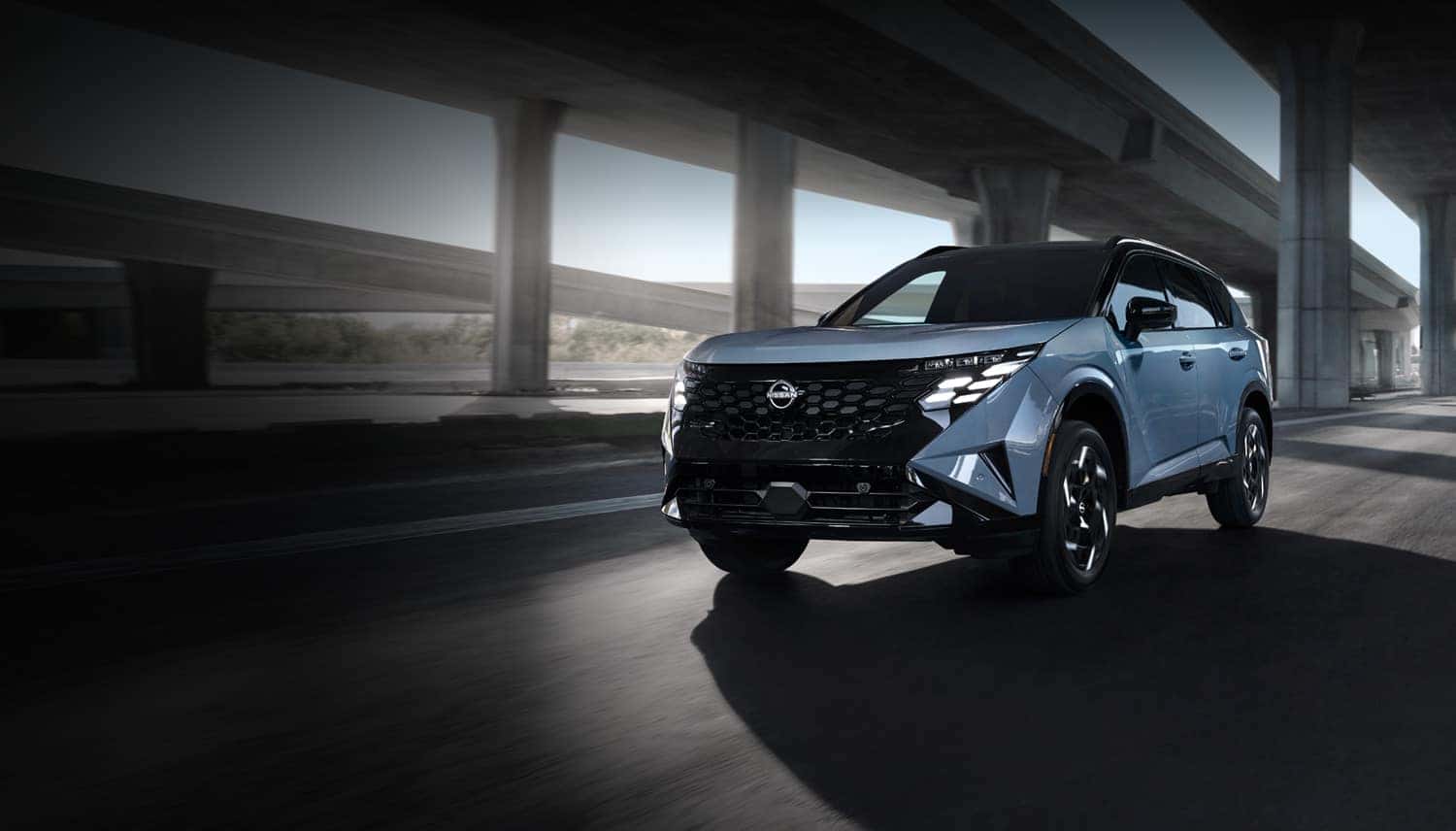 2027 Nissan Rogue Hybrid driving beneath an overpass