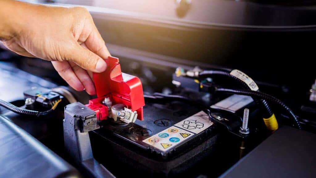 A technician inspecting a vehicle's battery