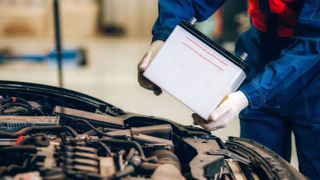 A technician installing a new vehicle battery