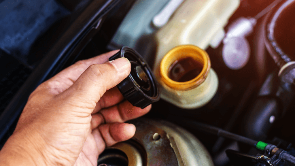A technician checking a vehicle's brake fluid