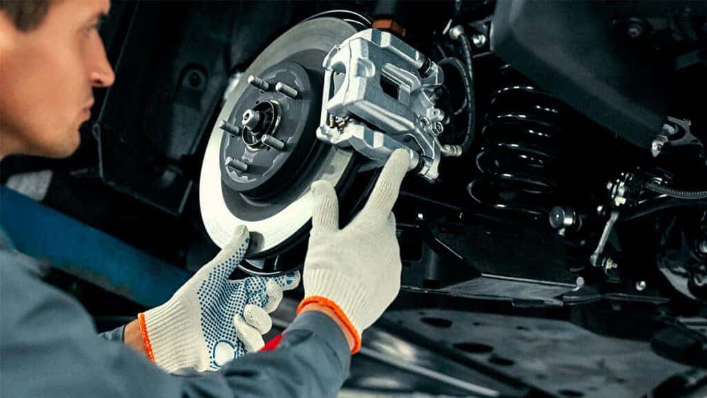 A technician inspecting a vehicle's brake system